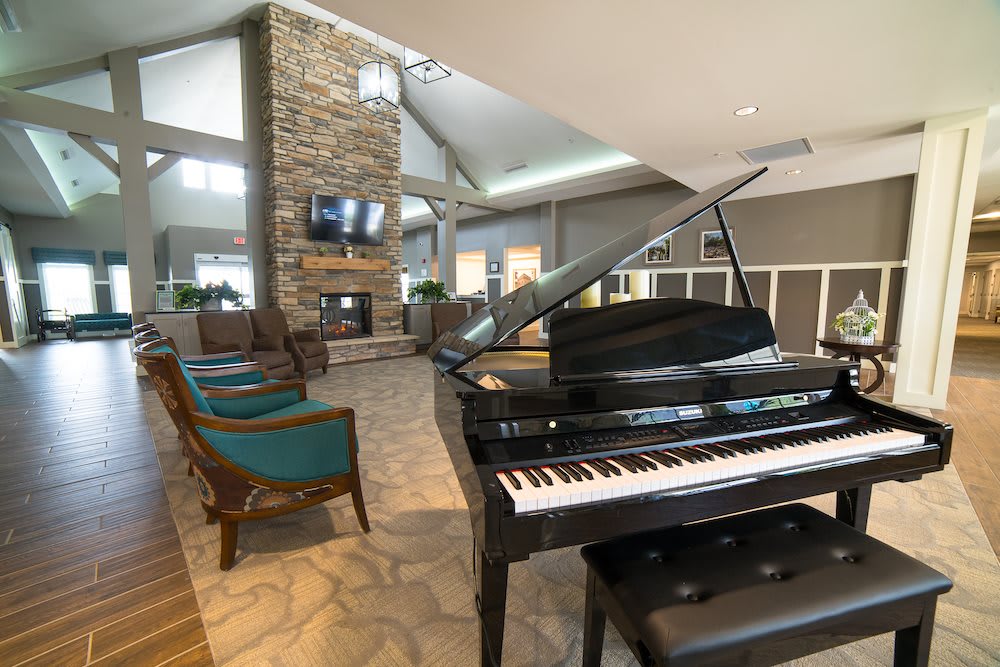 A modern living room featuring a grand piano and a cozy fireplace.