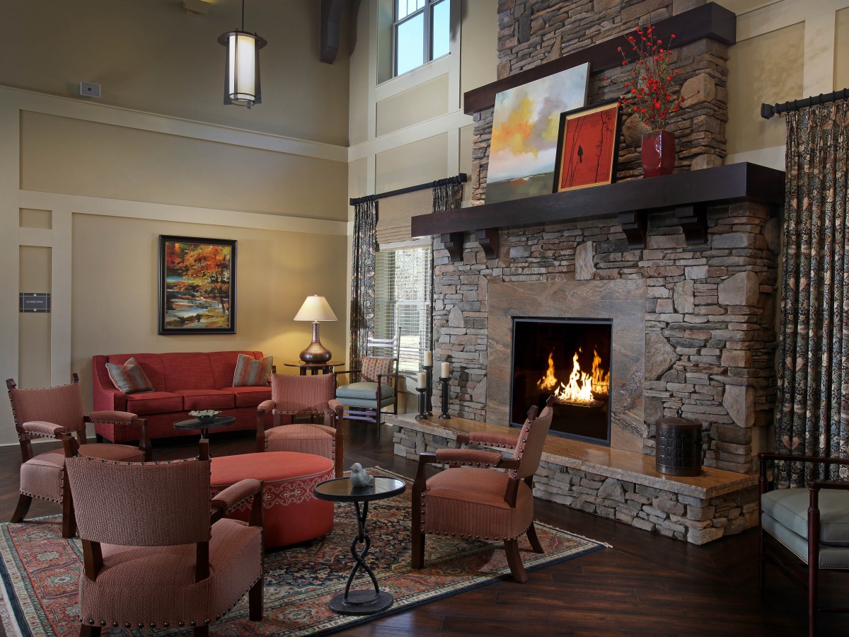 A cozy living room with a stone fireplace and comfortable seating.