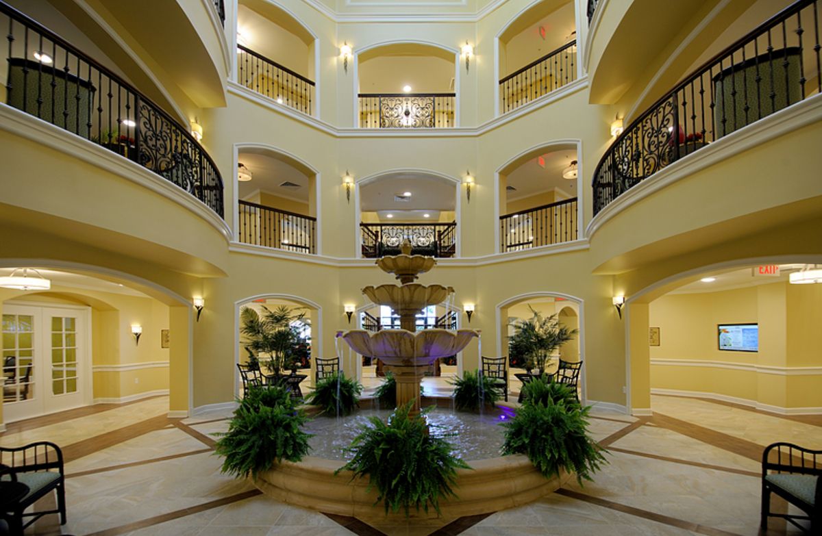 A luxurious multi-level atrium with a central fountain and surrounding balconies.