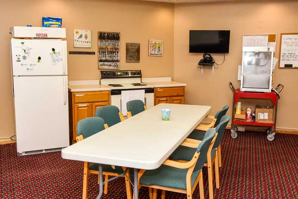 A kitchen and dining area with a table, chairs, television, and appliances.
