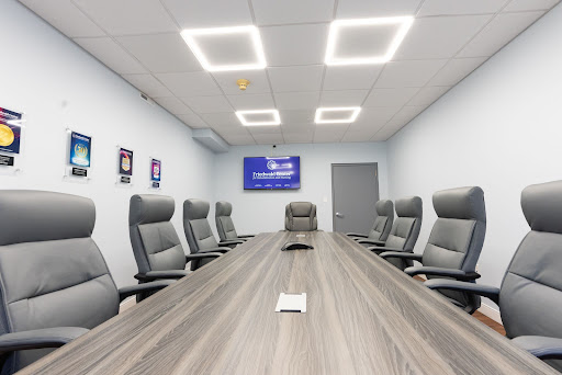 A modern conference room equipped with ergonomic chairs and a spacious meeting table, ideal for business discussions.