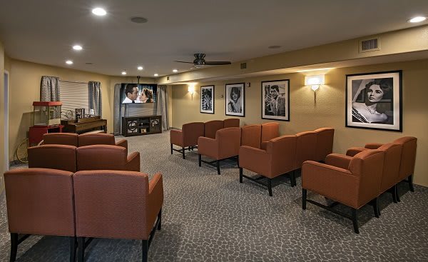 A cozy seating area with comfortable chairs, a television, and framed pictures on the walls.
