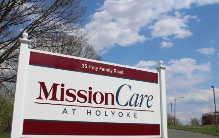 Sign for MissionCare at Holyoke against a blue sky backdrop.