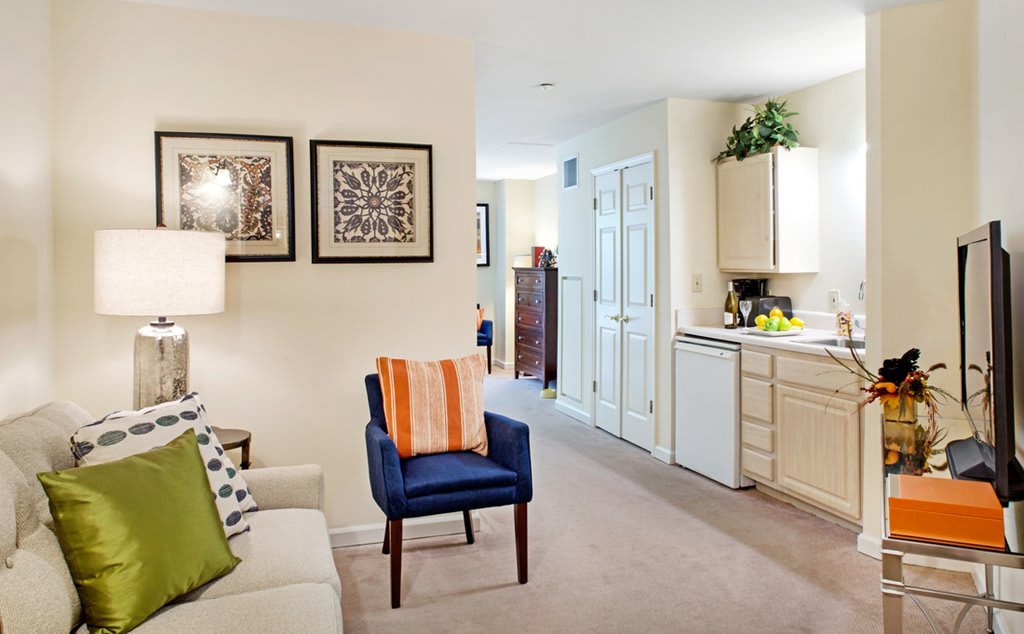 A cozy living space featuring a sofa, armchair, and decorative artwork.