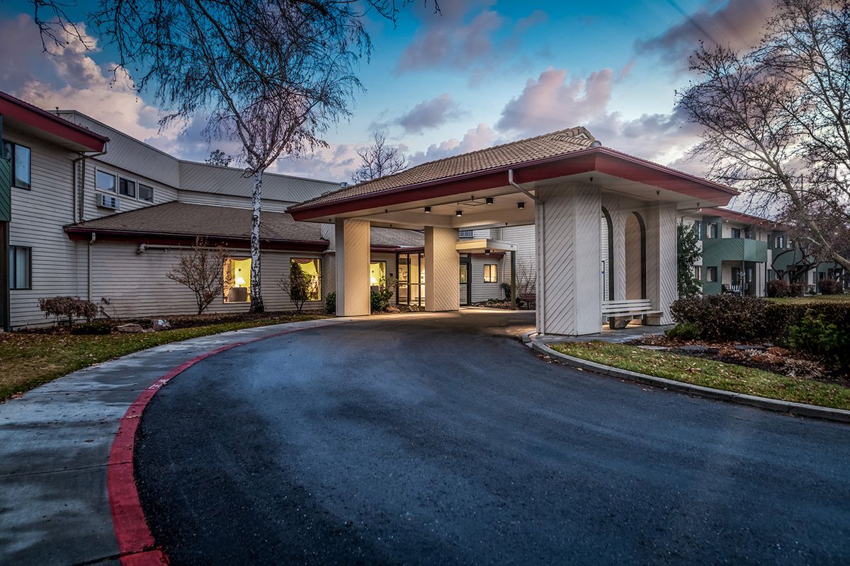 Evening view of a building entrance with a driveway.