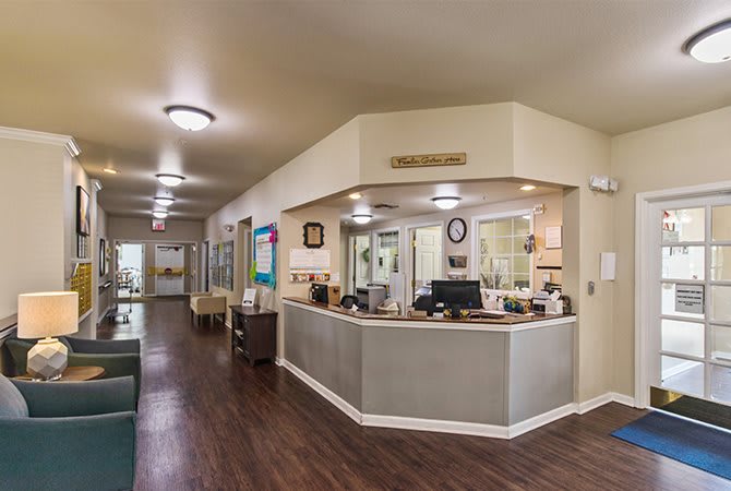 A spacious reception area with a desk and seating in an office environment.