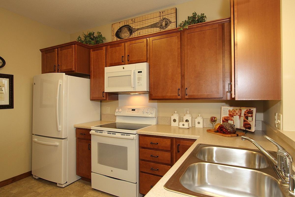 A cozy kitchen featuring wooden cabinets and white appliances.