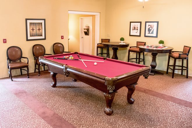 A cozy recreational room featuring a red felt pool table and elegant furnishings.