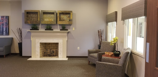 A stylish and cozy living room featuring a modern fireplace and comfortable seating.