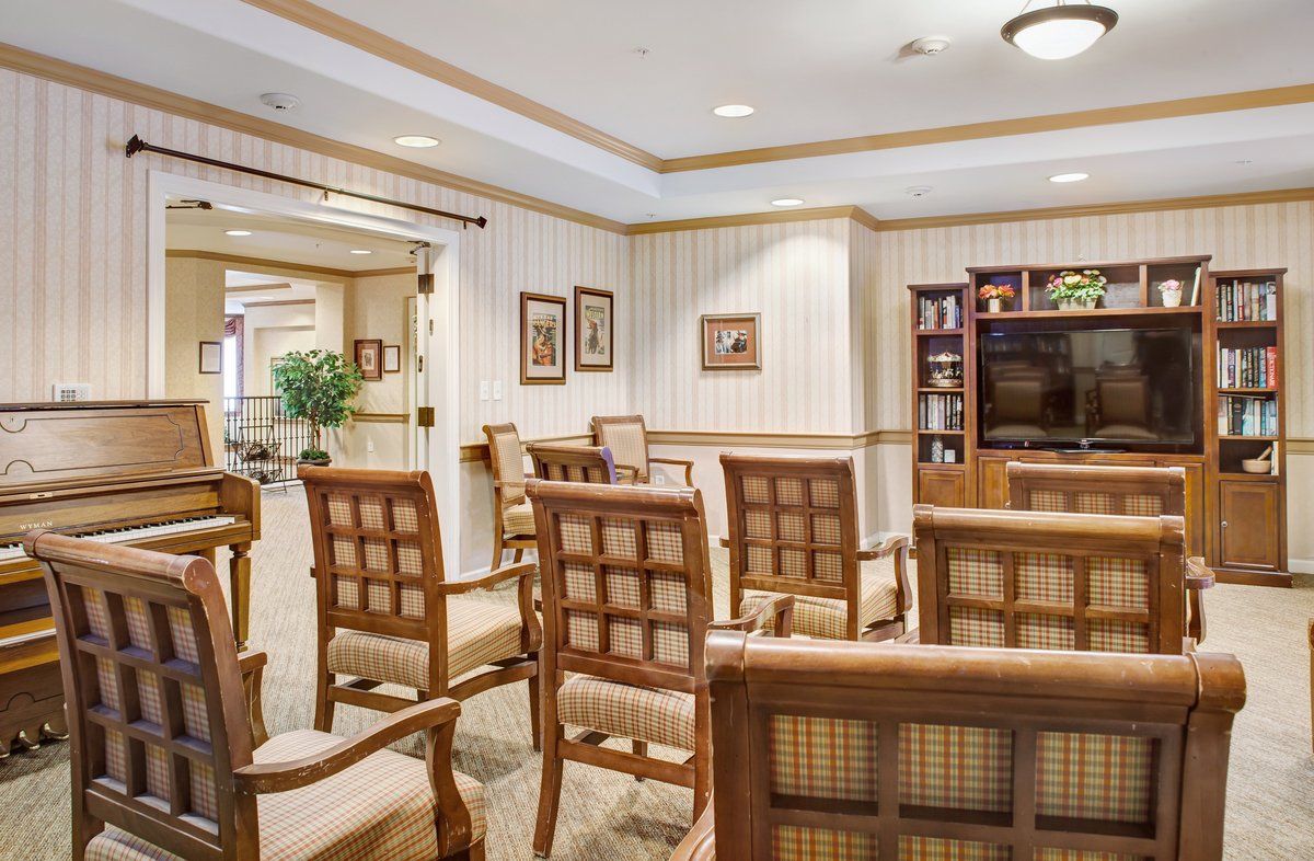 A well-furnished waiting room with arranged seating, decor, and a TV stand.