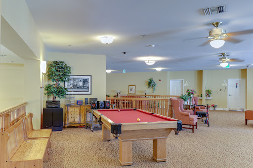 A spacious indoor game room featuring a pool table and comfortable seating areas.