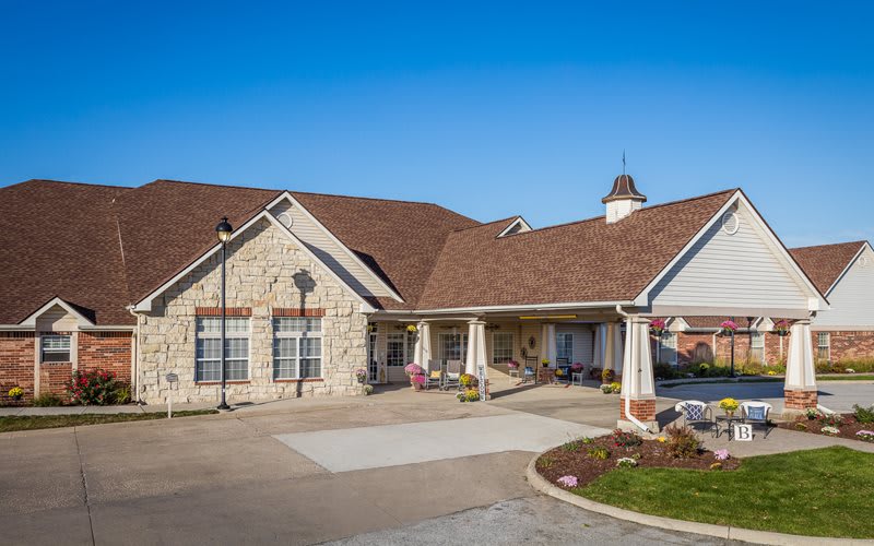 A residential building with a brick exterior and driveway under a clear blue sky.