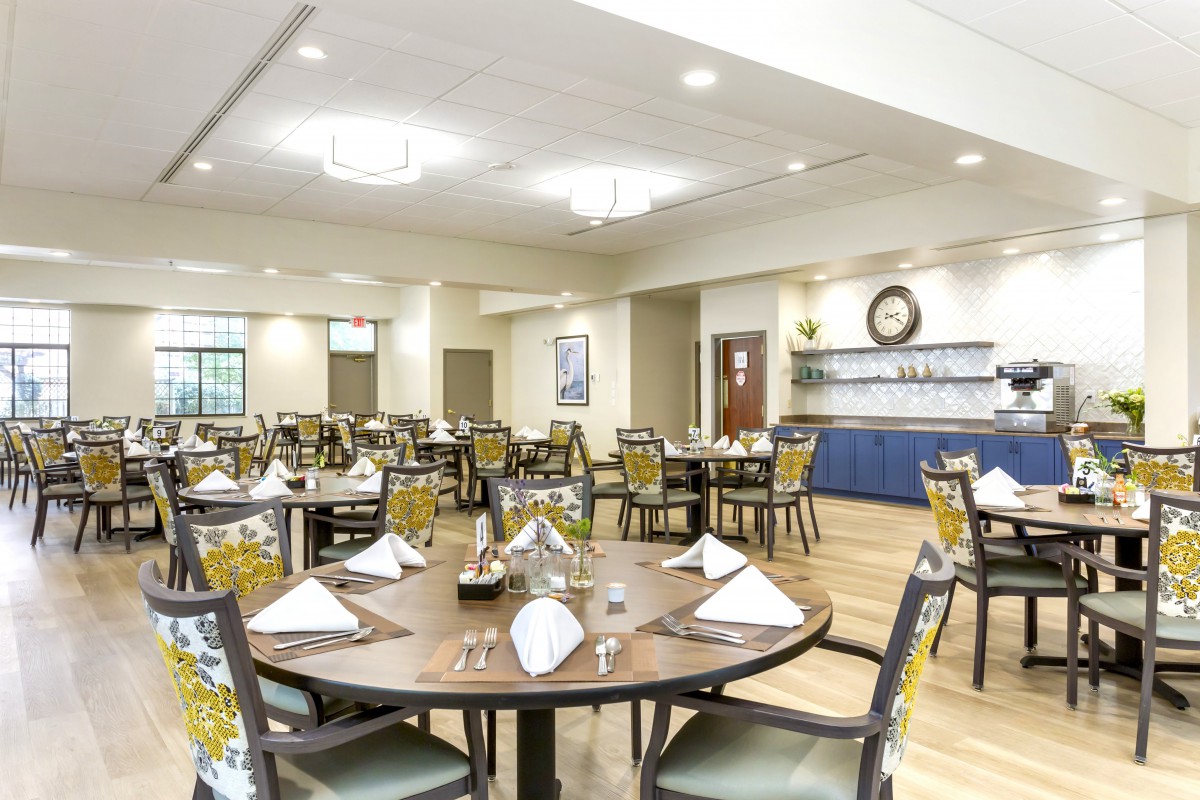 An elegantly set dining room with neatly arranged tables and chairs, ready for guests.