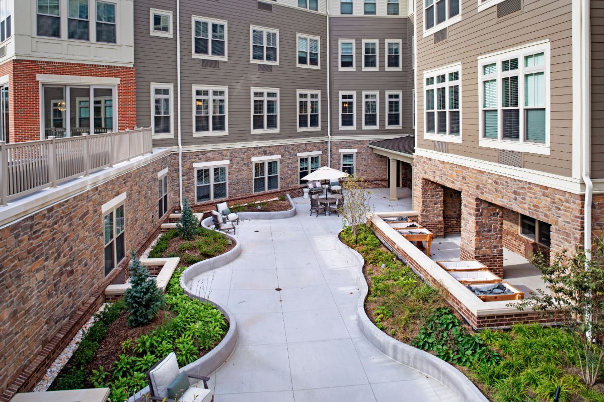 A modern residential courtyard with landscaping and outdoor seating areas.