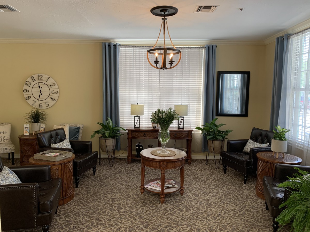 A cozy and well-decorated living room with comfortable seating, plants, and elegant lighting.