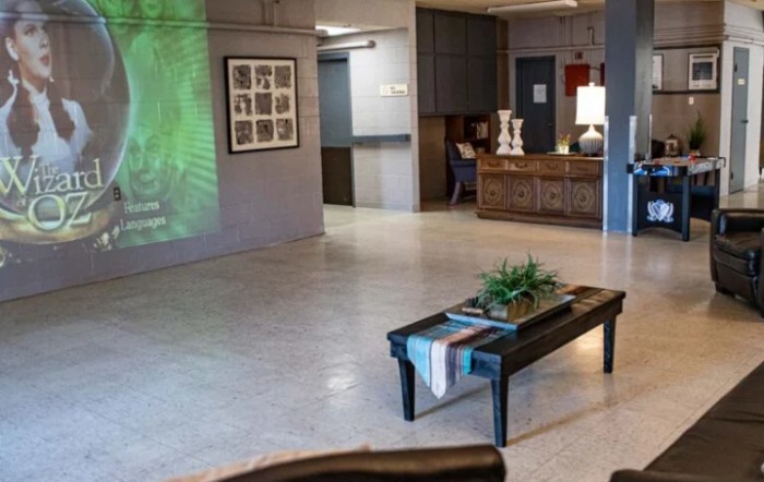 A cozy lobby area featuring a reception desk, decorative plants, and artwork on the wall.