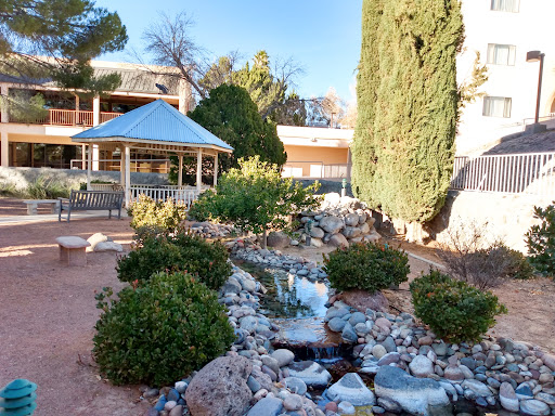 A serene garden featuring a flowing stream, decorative rocks, and a charming gazebo.