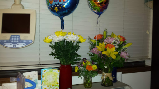 A festive display of balloons and vibrant flower arrangements, perfect for a celebration.