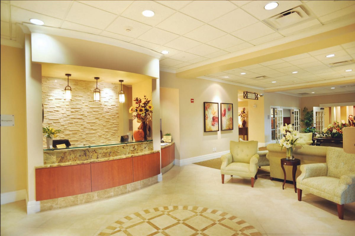 A well-lit lobby with a reception desk, seating area, and decorative elements.