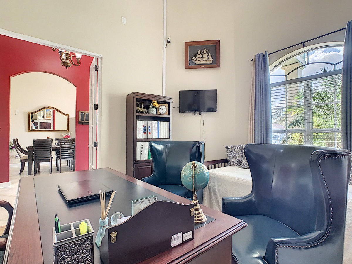 A cozy office space with a large desk, globe, and comfortable chairs.