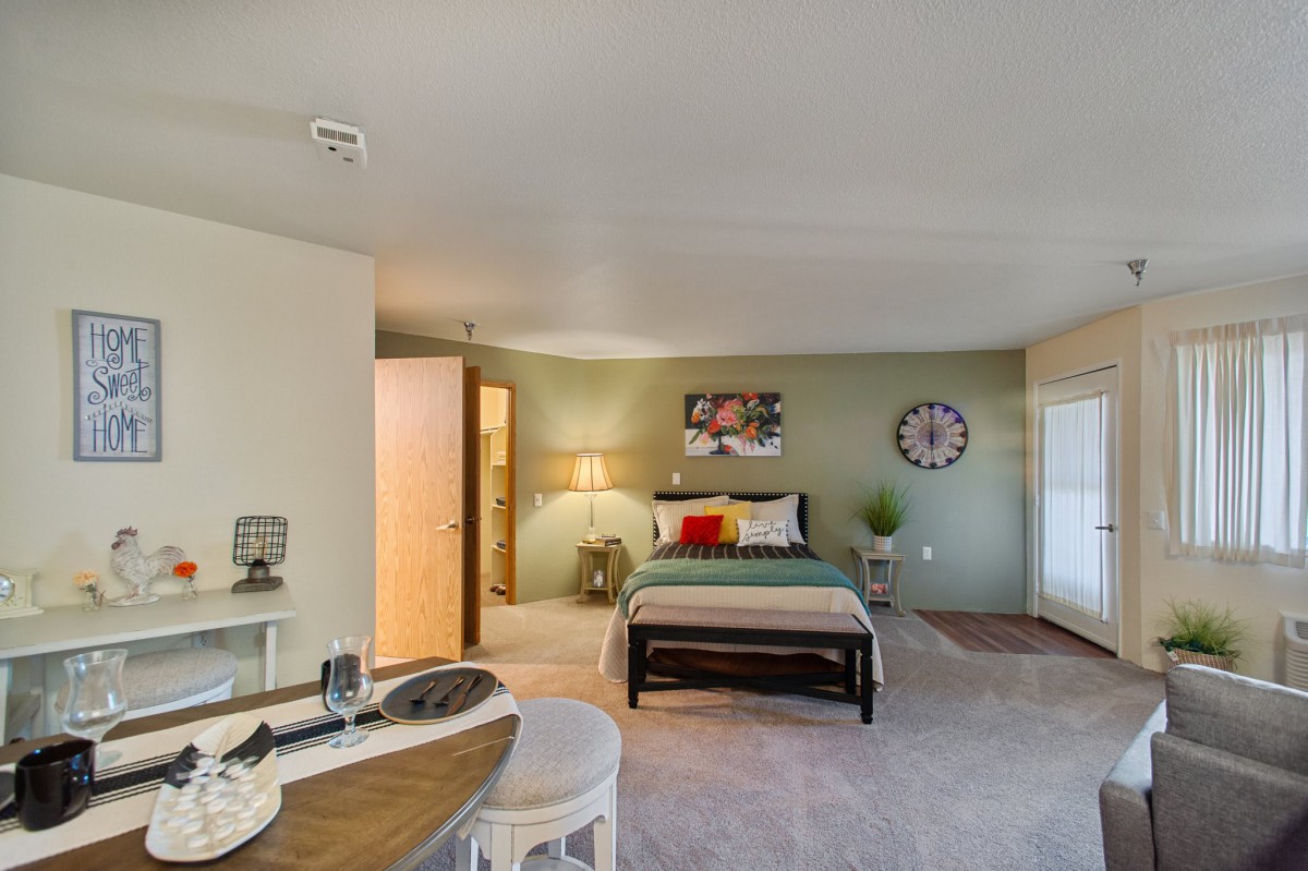 A modern and cozy bedroom with tasteful decor and furniture, featuring a carpeted floor.