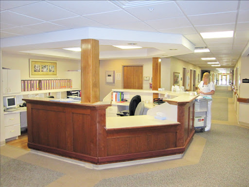 A spacious reception area in a healthcare facility, featuring wooden accents and a welcoming atmosphere.