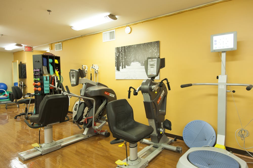A gym room with various exercise machines and equipment.