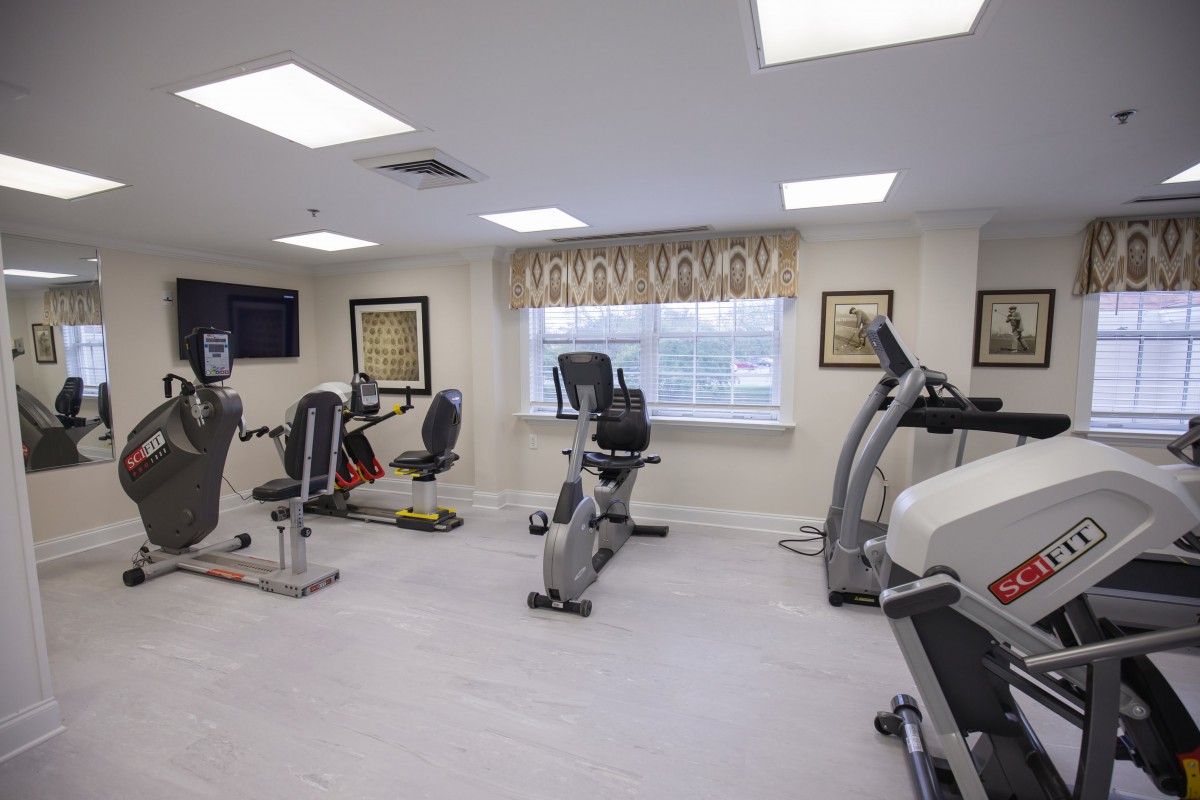A fitness room equipped with various exercise machines including treadmills and stationary bikes.