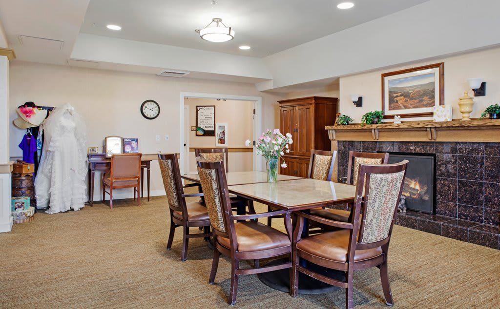 A cozy dining area with a table, chairs, and a fireplace.