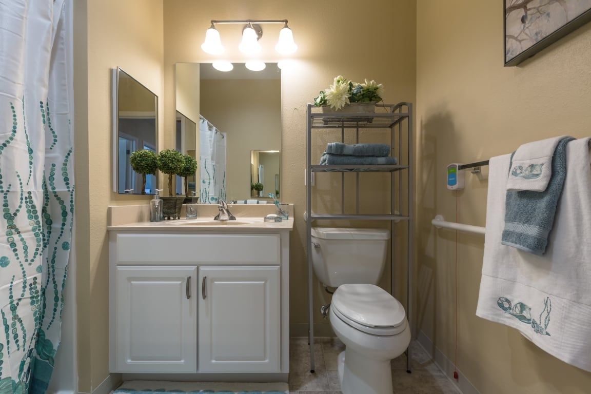 A well-organized bathroom with a vanity, mirror, and storage shelves.