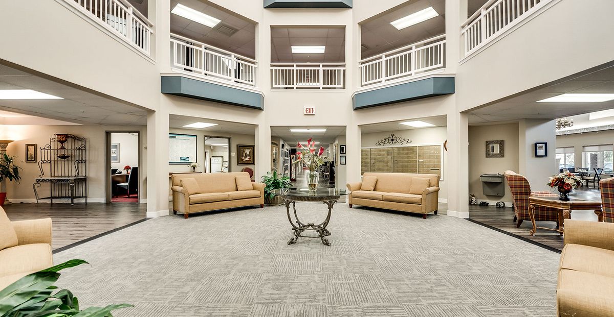 A spacious lobby area featuring two sofas and a central table with floral decoration.