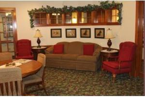 A cozy living room with a sofa, armchairs, and decorative elements.