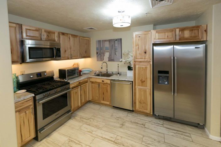 A modern kitchen featuring stainless steel appliances and wooden cabinets.