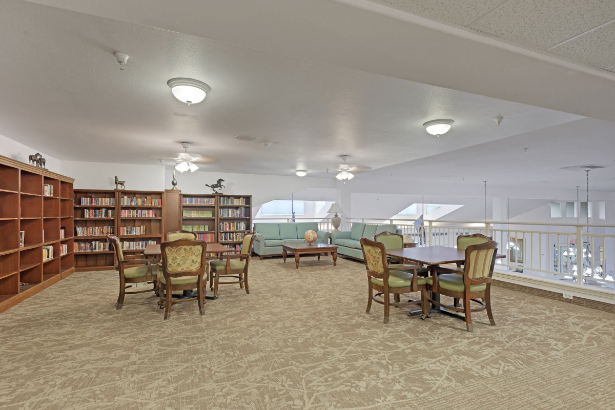 A cozy library reading area with bookshelves and seating arrangements.