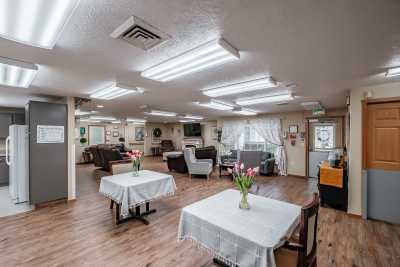 A well-lit dining area with tables set and flowers on display.