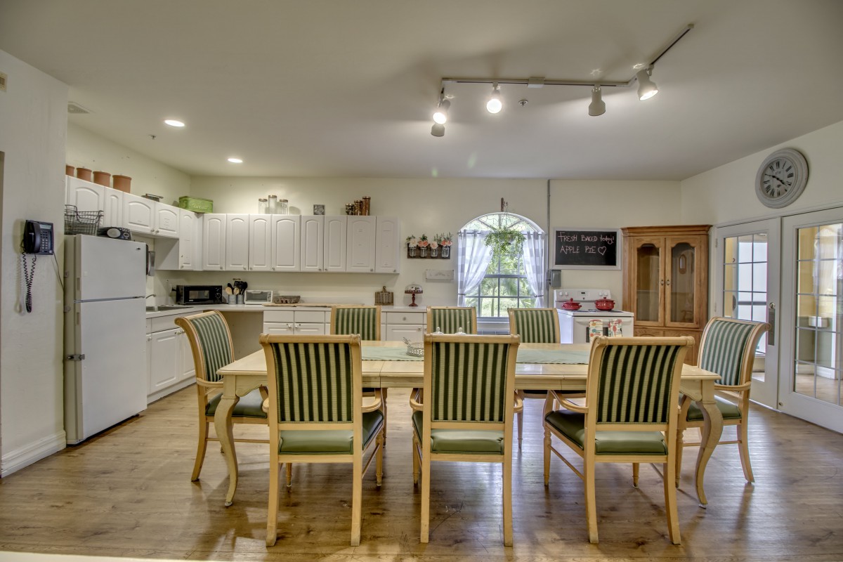 Spacious kitchen with a dining area, featuring a large table and striped chairs.