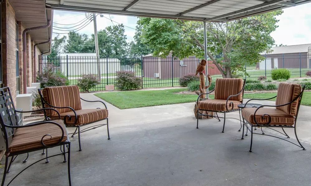 A cozy patio with outdoor chairs overlooking a well-maintained garden.