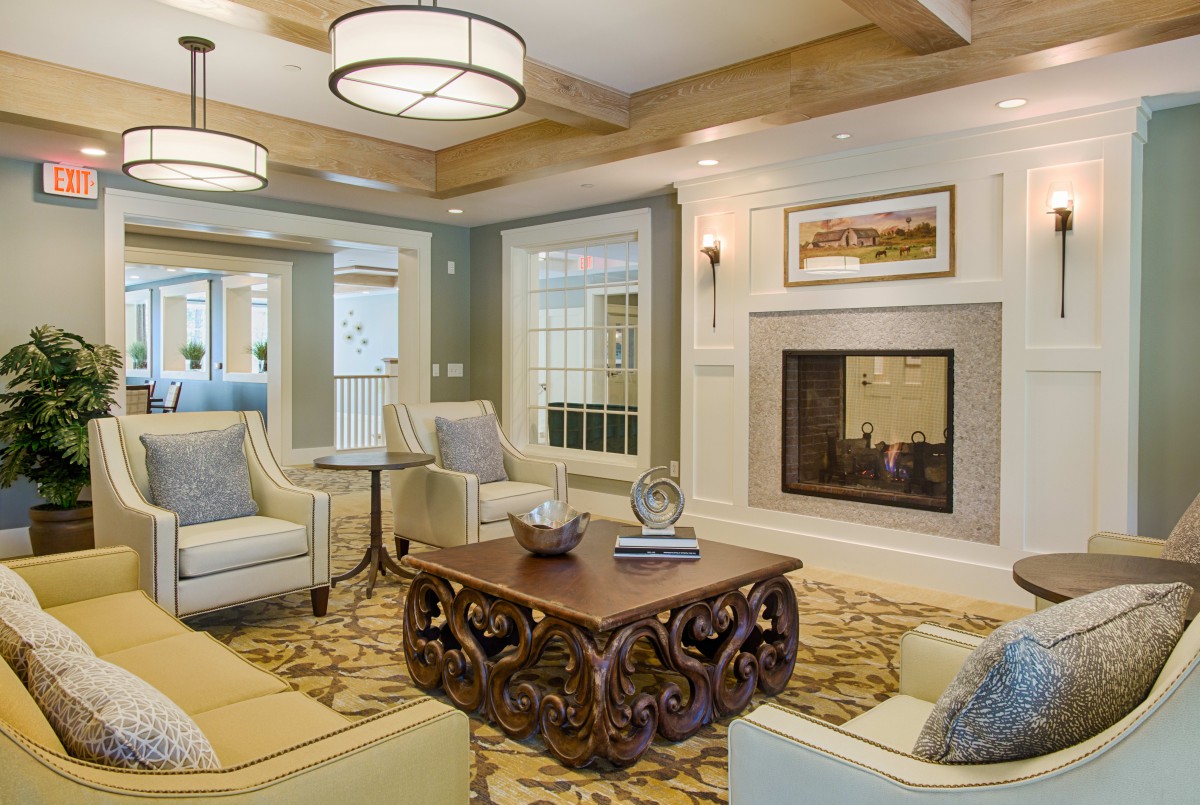 A cozy and elegantly furnished living room featuring a fireplace and comfortable seating.