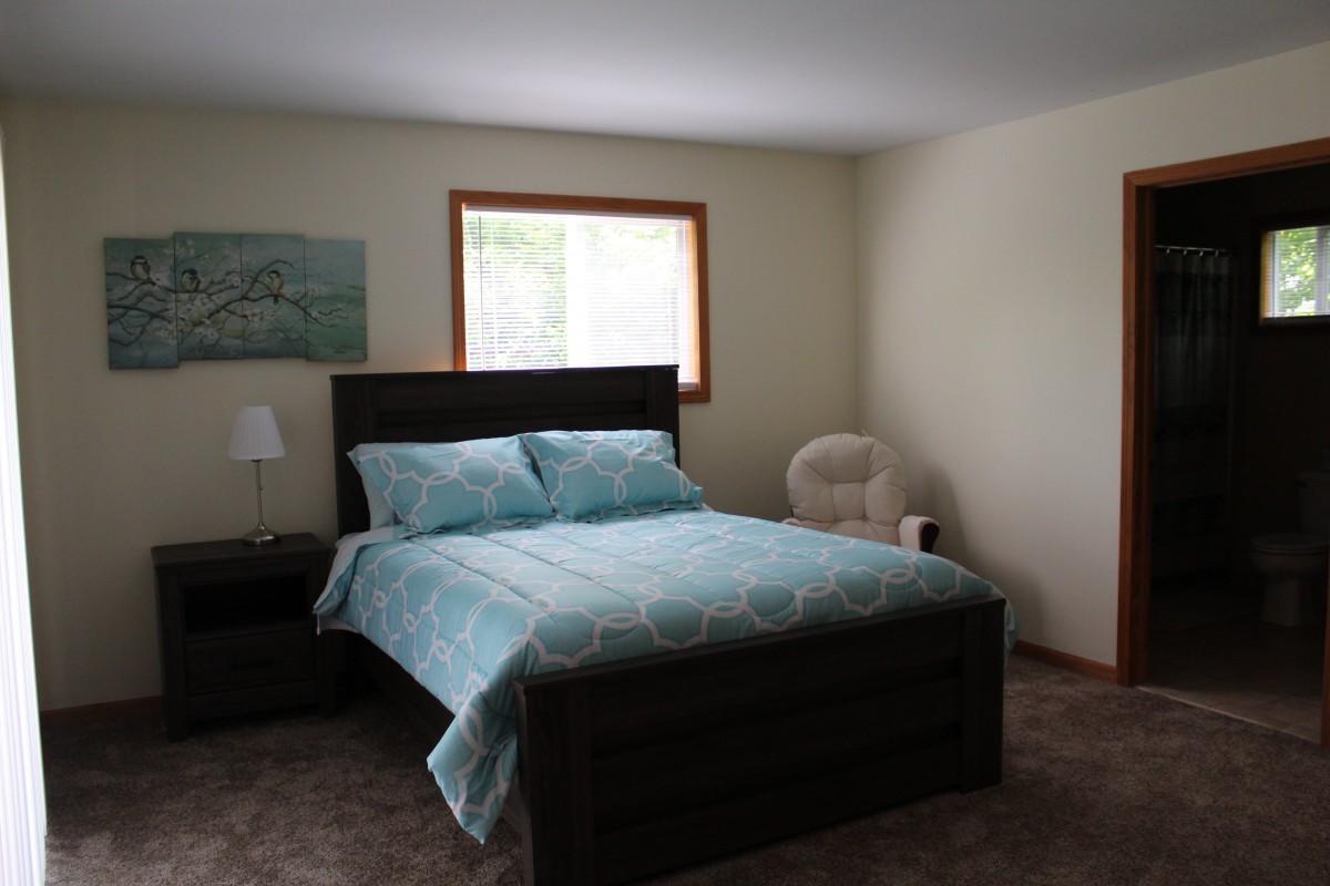 A cozy bedroom with a neatly made bed and soft lighting.