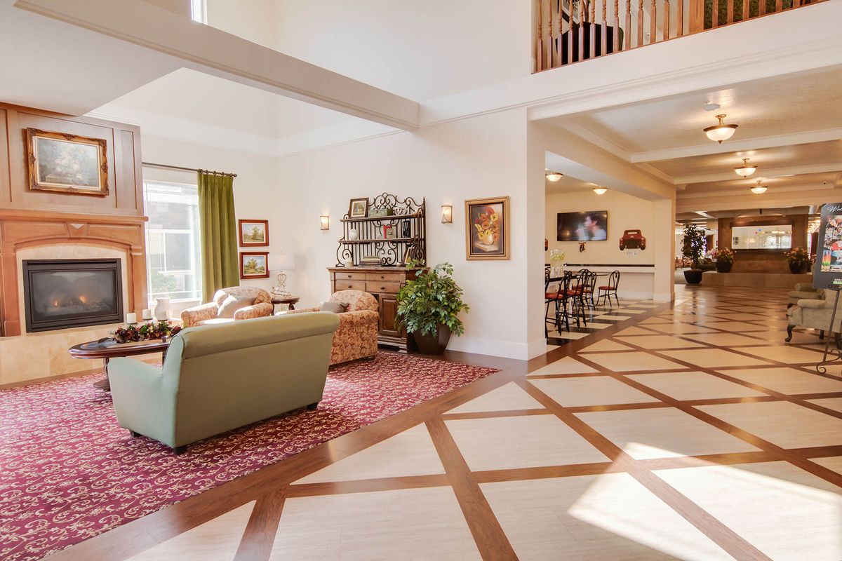 A spacious and modern living room with ample natural light, featuring comfortable furniture and elegant decor.