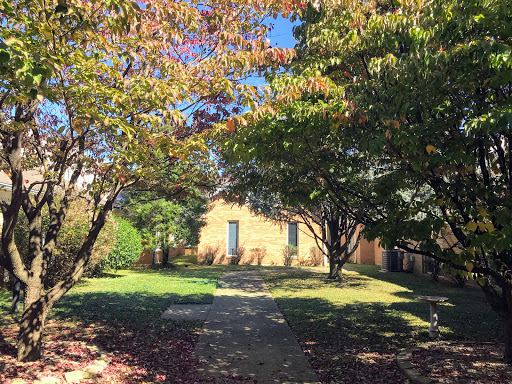 A picturesque view of a pathway leading to a house, framed by colorful autumn trees.