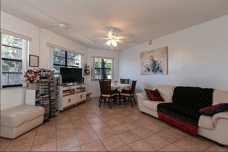 A cozy living room with a dining table, sofa, and television.