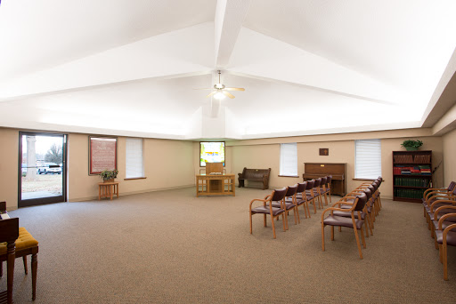 A spacious and well-lit interior with chairs arranged in rows, suitable for gatherings or meetings.