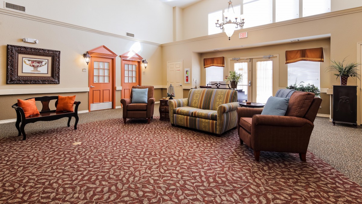 A cozy lobby with comfortable seating arrangements and a decorative chandelier.