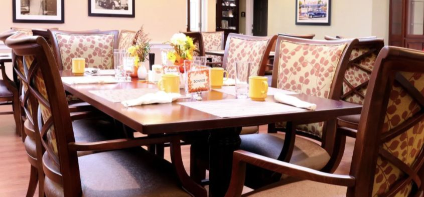 A set dining table with cups and floral arrangements in a restaurant setting.
