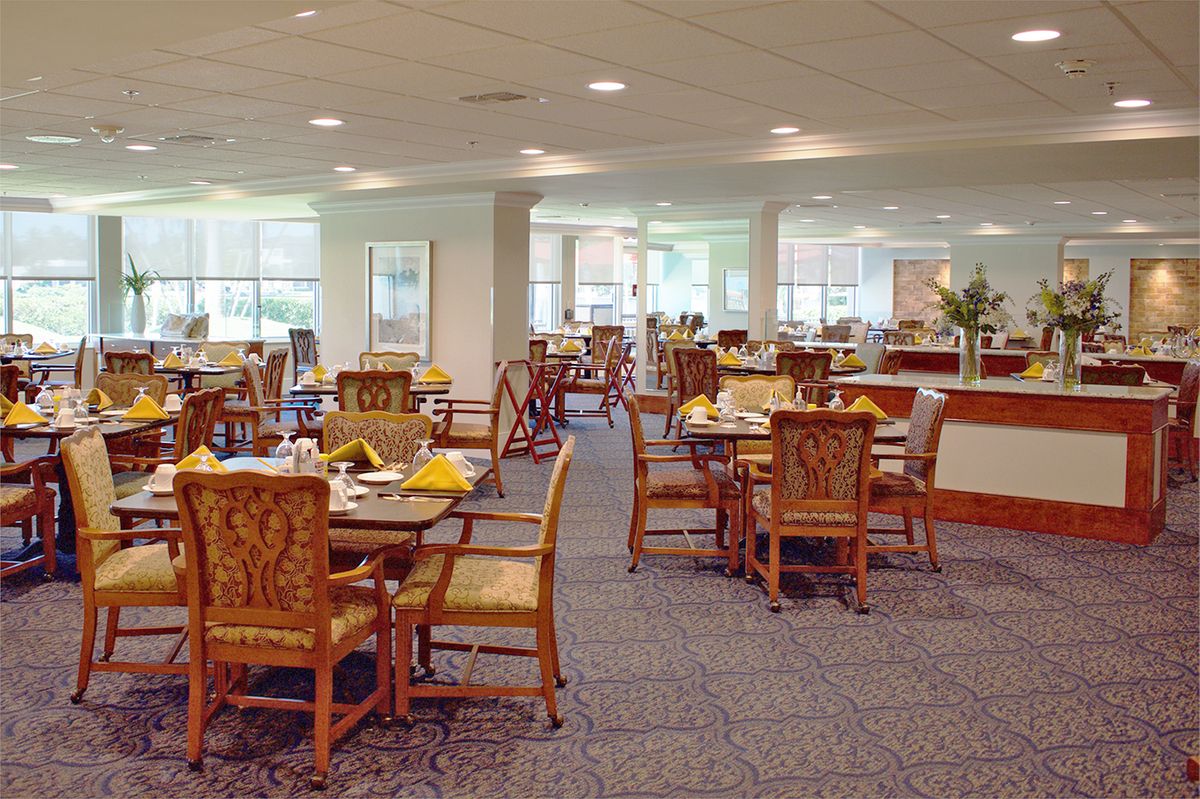 An empty dining room with neatly set tables and chairs.