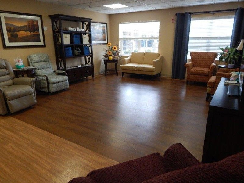 A cozy living room with hardwood flooring and multiple seating options.