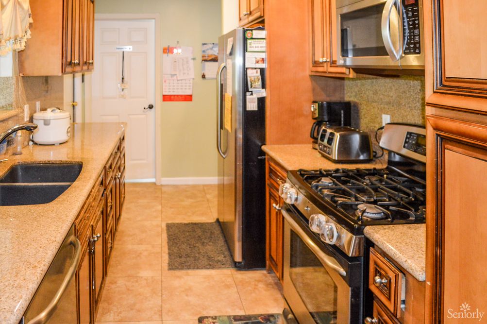 A modern kitchen with stainless steel appliances and wooden cabinetry.