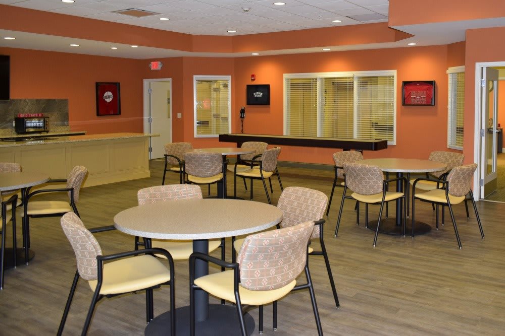 A community seating area with tables and chairs in a warmly decorated room.