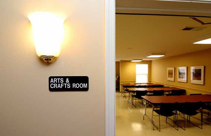 An empty arts and crafts room with tables and chairs arranged neatly.